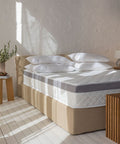 Matratzen Bundle mit Taschenfederkernmatratze und federfreiem Topper auf modernem Bettgestell in einem hellen Schlafzimmer.