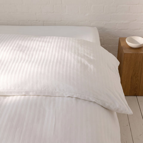 Excellence Microstripe Bettwäsche mit feinem Streifenmuster auf Kissen und Bettdecke in stilvoller Luxushotel-Optik.