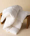 Excellence Natürlicher Topper mit voluminöser Füllung auf einem Holzhocker, präsentiert als hochwertige Ergänzung für mehr Schlafkomfort.