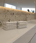 Premium Luxushotel-Waschlappen 10er Set mit sauber gefalteten weißen Waschlappen auf einer modernen Badezimmerablage in exklusivem Hotelambiente.
