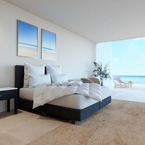 Modernes Schlafzimmer mit federfreier Bettdecke und passenden Kissen in heller Einrichtung